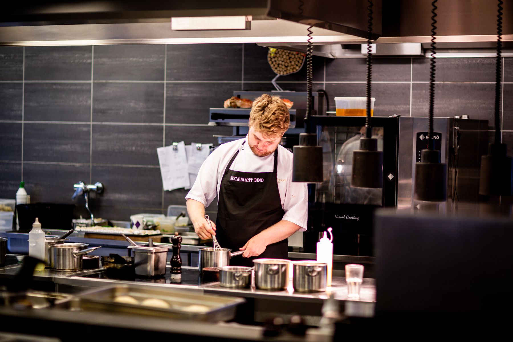 Koch bei der Zubereitung in einer professionellen Restaurantküche